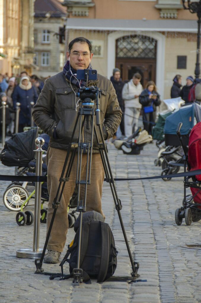 Man Filming with Cellphone on Tripod on Street